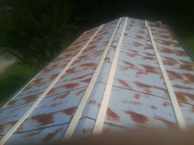 Rusted metal roof panels with new wood purlins before replacement — Storm Damage Roof Repair in Carnegie by Roofing Brothers