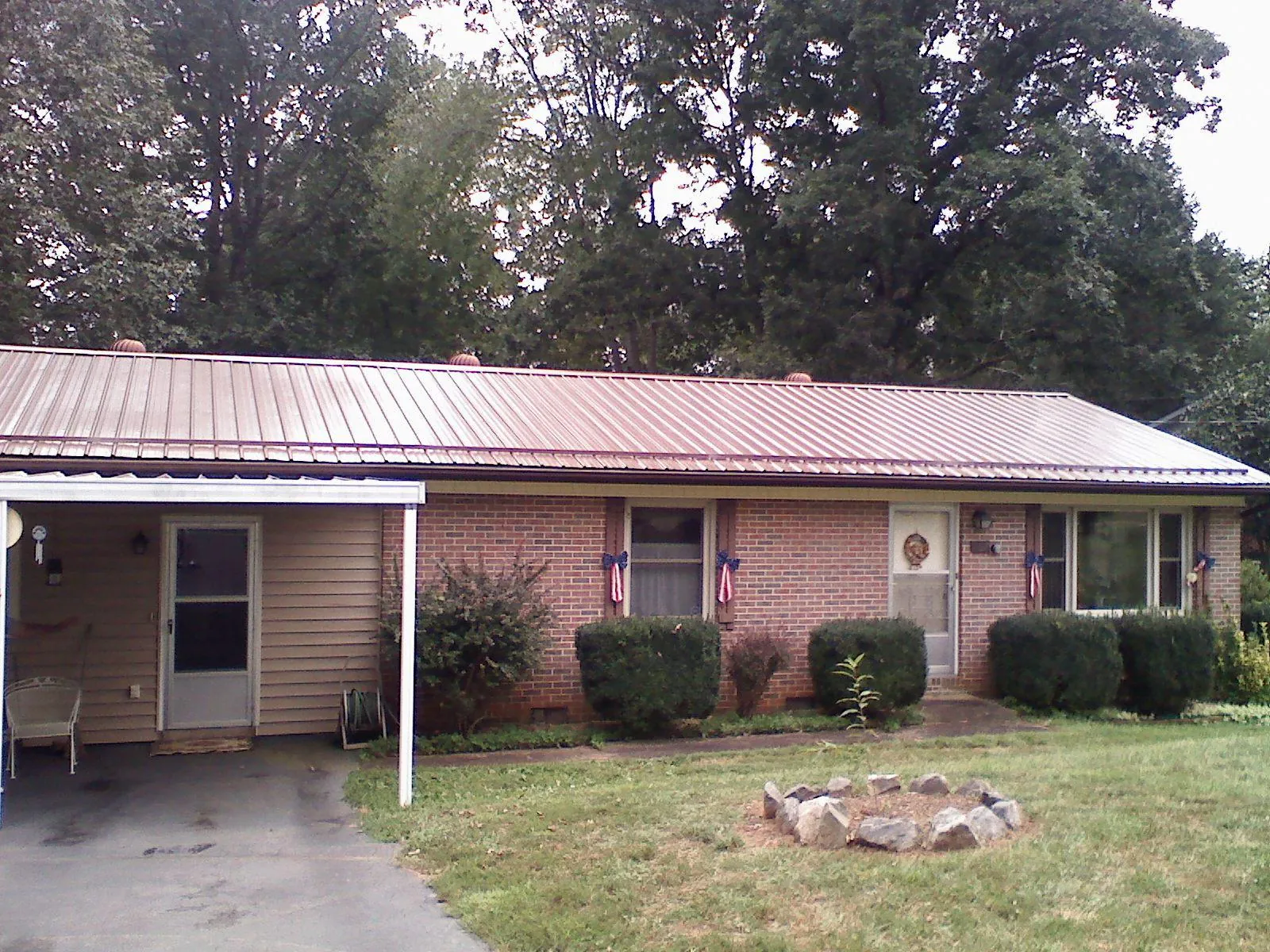 Bronze metal roof and carport on a brick ranch home — Roof Repair work by our crew in Carnegie